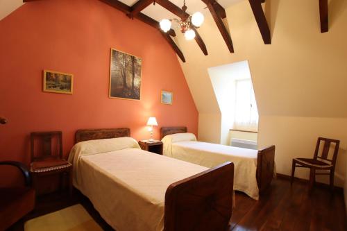 two beds in a room with orange walls at Domaine Garmidou in Lucq-de-Béarn