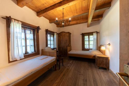 a room with two beds and windows and wooden ceilings at Polana Sosny in Niedzica Zamek