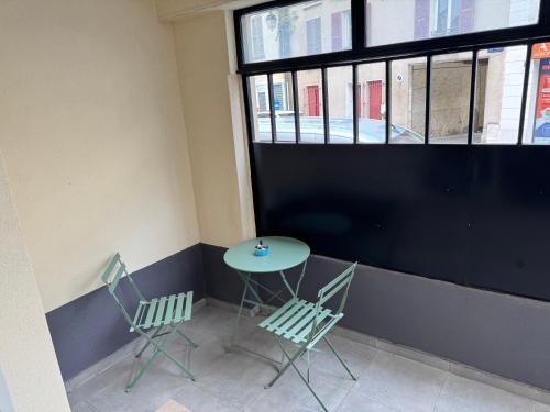 a table and chairs in a room with a window at Studio SN1 - Centre-Ville Meaux - Proche Disneyland in Meaux