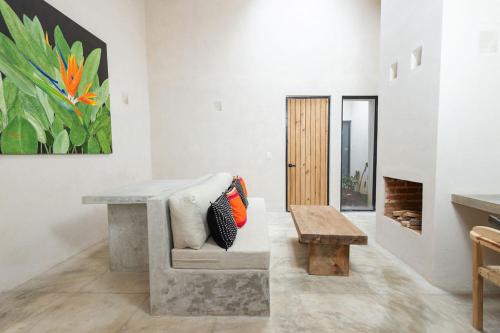 a living room with a bench and a painting at Jungla Hotel Boutique in San Cristóbal de Las Casas