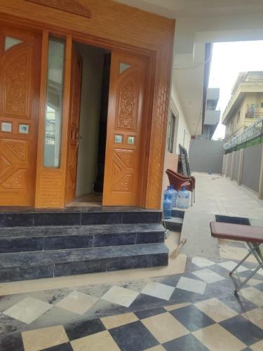 a pair of wooden doors on a building with stairs at Ayyan Cottage G 10-2 in Islamabad