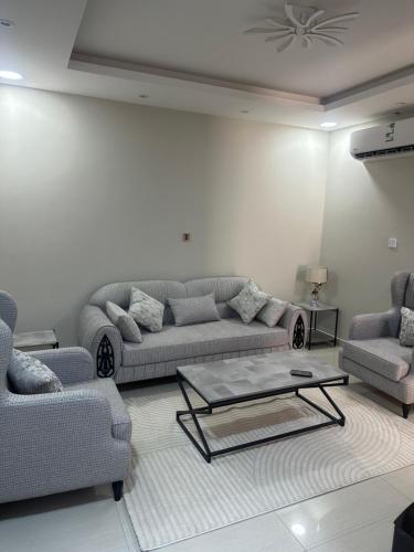 a living room with couches and a coffee table at نزل جنى 2 in Dammam