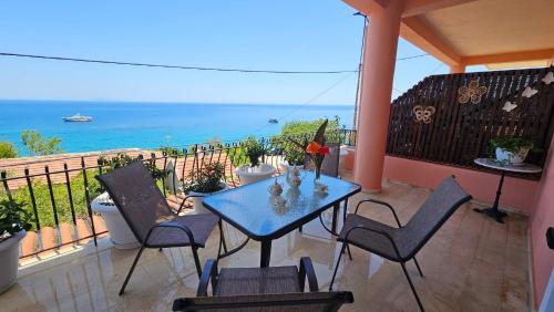 a balcony with a table and chairs and the ocean at Georgia's Skyview in Póros Kefalonias