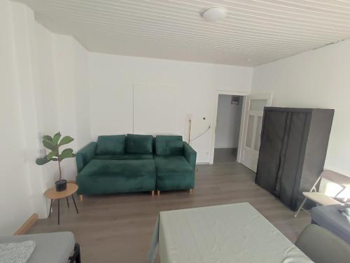 a living room with a green couch and a table at Bright and Spacious Apartment in Wiesbaden City Center in Wiesbaden