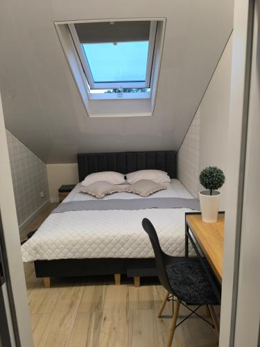 a bedroom with a bed with a window and a chair at Restauracja Dajana in Bełchatów