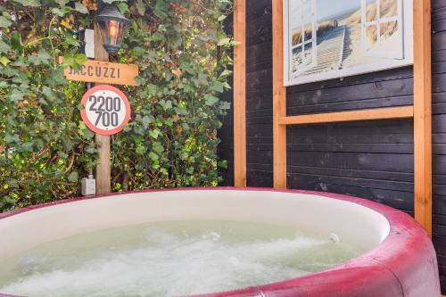 a bath tub in front of a house with a speed limit sign at Wellness apartment Apeldoorn with Sauna and Jacuzzi in Apeldoorn