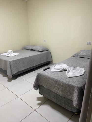 two beds sitting in a room with at Pousada Império in Chapada dos Guimarães