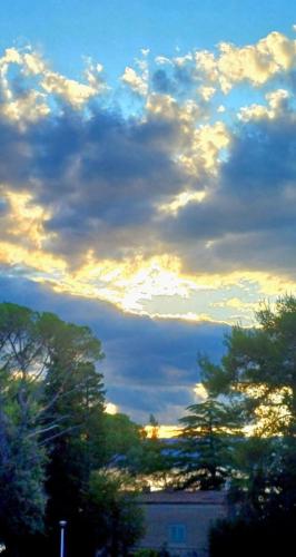 a cloudy sky with trees and a building at Apartman Ivona in Malinska