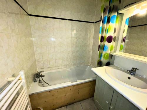 une salle de bain avec une baignoire et un lavabo dans l'établissement Résidence Bosson - 4/6 pers ski au pied aux Menuires - accès 3 Vallées MAE-3844, aux Menuires