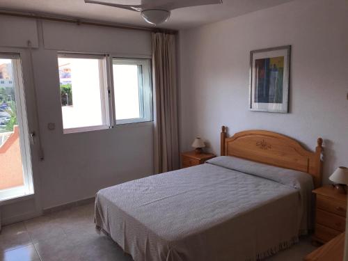 a bedroom with a bed and two windows at DUPLEX 3 DORMITORIOS en LA MANGA in San Javier