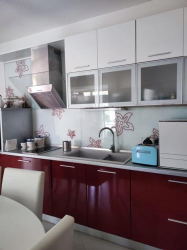 a kitchen with white cabinets and a sink at Evi's house in Iraklitsa