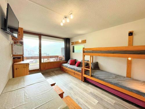 une chambre avec deux lits superposés et un canapé dans l'établissement Résidence Chaviere - Studio pour 4 personnes avec balcon exposé Sud MAE-5494, aux Menuires