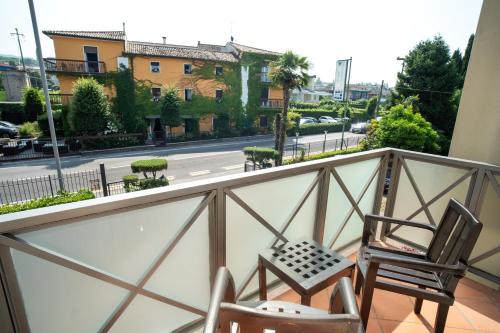a balcony with two chairs and a view of a street at Hotel Campagnola in Bardolino
