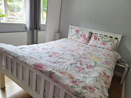 a bed with a floral comforter and pillows at Tullydish in Kilmacanoge