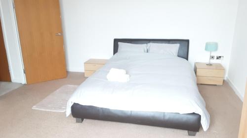a bedroom with a large bed with white sheets and pillows at Elegant three bedroom apartment in Darlington