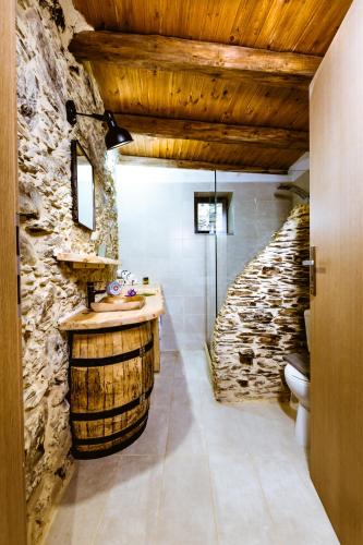 a bathroom with a sink and a stone wall at Traditional Apartments Elafos in Elafonisi
