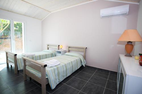 two beds in a room with a table and chairs at Pace rurale con stile, 3 camere 2 bagni in Piazza Armerina