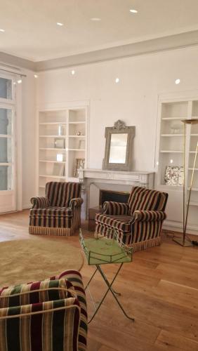 a living room with two chairs and a fireplace at Apartment Joie de Vivre in Béziers