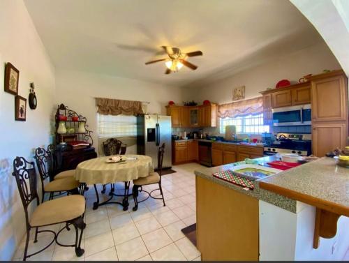 a kitchen with a table and a kitchen with a ceiling fan at Tranquila Oasis in Runaway Bay