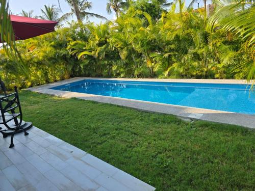 a swimming pool in a yard with a chair next to it at Beautiful home in El Tigre golf course Nuevo Vallarta! in Nuevo Vallarta 