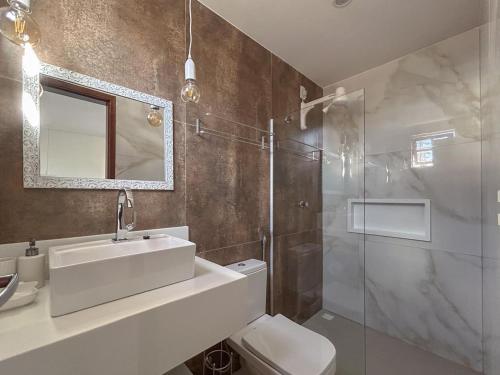 a bathroom with a sink and a toilet and a shower at Charme da Vila Suítes in Porto De Galinhas