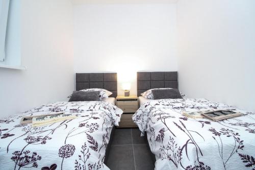 Habitación con 2 camas individuales y paredes blancas. en Fly in Apartment, en Čilipi