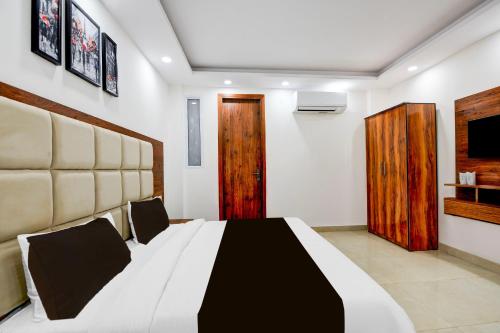 a bedroom with a black and white bed and a television at Super Collection O Hotel Evergreen in Faridabad