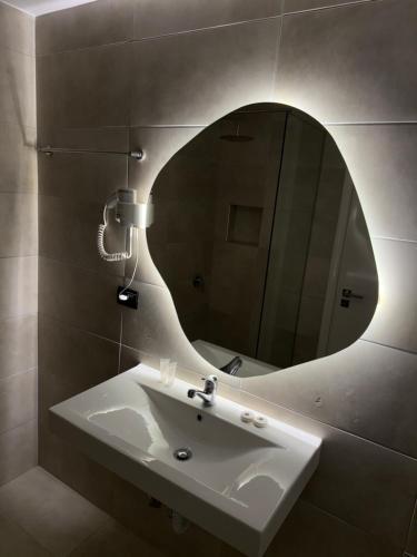 a bathroom with a sink and a mirror at Diamond Central Boutique Hotel in Sarandë