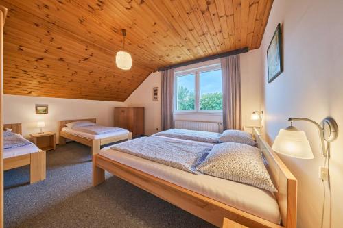 a bedroom with two beds and a large window at Apartmán Svoboda in Svoboda nad Úpou