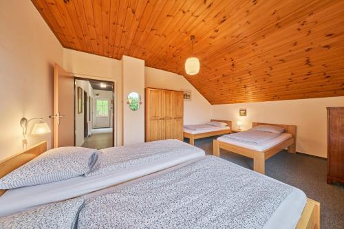 a bedroom with two beds and a wooden ceiling at Apartmán Svoboda in Svoboda nad Úpou
