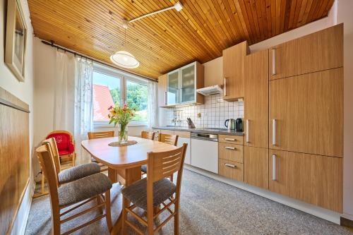 a kitchen with a wooden ceiling and a table and chairs at Apartmán Svoboda in Svoboda nad Úpou