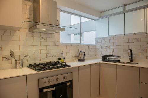 リマにあるMagnificent 3BR in the Heart of Barrancoのコンロ付きのキッチン 窓際の上部オーブン
