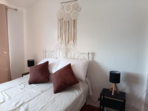a bedroom with a white bed with two pillows at Casa Calhameiro in Redondo