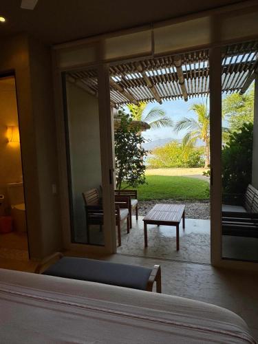 a bedroom with a bed and a view of a patio at Punta Majahua by PRC Hospitality in La Majahua