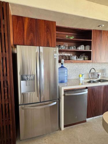 a kitchen with a stainless steel refrigerator and a sink at Punta Majahua by PRC Hospitality in La Majahua