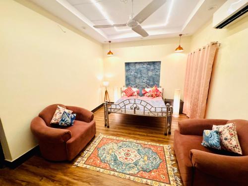 a living room with two chairs and a table at The Family Courtyard, 4 BR Boutique Villa and Guest House in Lucknow