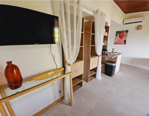 a living room with a flat screen tv on a wall at Ti Oasis SEAVIEW, Studio Vue Mer à 150m de la plage in Corps de Garde