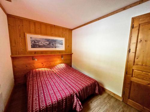 une petite chambre avec un lit avec une couverture rouge dans l'établissement Résidence Courmayeur - Bel appartement rénové pour 6-8 personnes sur les pistes MAE-4094, aux Menuires