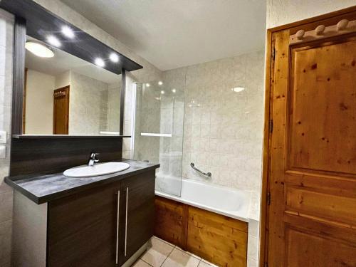 une salle de bain avec un lavabo et une baignoire dans l'établissement Résidence Courmayeur - Bel appartement rénové pour 6-8 personnes sur les pistes MAE-4094, aux Menuires
