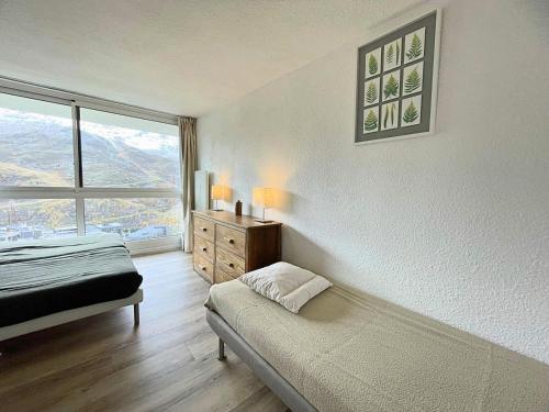 une chambre avec un lit et une grande fenêtre dans l'établissement Résidence Nant Benoit - Appartement 8 personnes aux Ménuires avec vue sur la montagne MAE-4404, aux Menuires