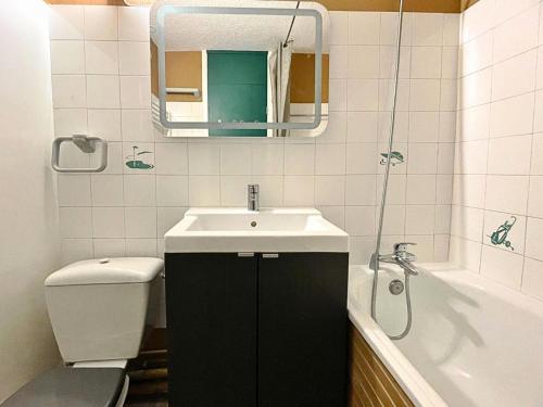 une salle de bain avec un lavabo, des toilettes et un miroir dans l'établissement Résidence Nant Benoit - Appartement 8 personnes aux Ménuires avec vue sur la montagne MAE-4404, aux Menuires