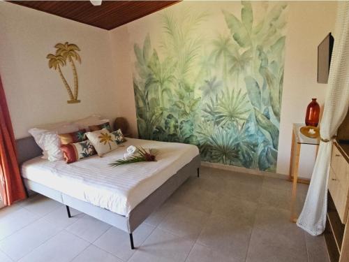 a bedroom with a bed with a painting on the wall at Ti Oasis SEAVIEW, Studio Vue Mer à 150m de la plage in Corps de Garde