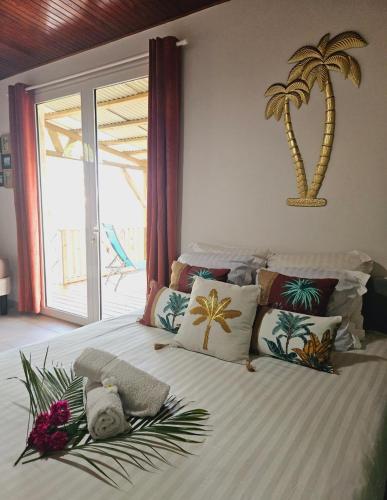 a bedroom with a bed with a palm tree on the wall at Ti Oasis SEAVIEW, Studio Vue Mer à 150m de la plage in Corps de Garde