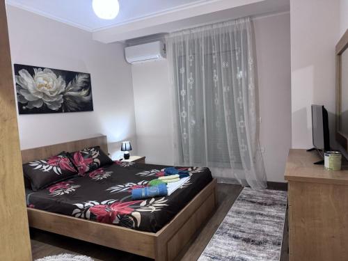 a small bedroom with a bed and a television at Anika's Place in Korçë