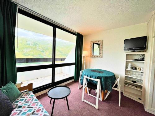 Cette chambre d'hôtel dispose d'une table et d'une grande fenêtre. dans l'établissement Résidence Tougnette - Studio de 19m2 équipé au pied des pistes aux Menuires MAE-1494, aux Menuires