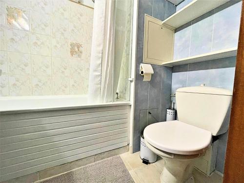 La salle de bains est pourvue de toilettes blanches et d'une baignoire. dans l'établissement Résidence Tougnette - Studio de 19m2 équipé au pied des pistes aux Menuires MAE-1494, aux Menuires