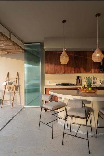 a kitchen with a table and chairs in a room at Punta Majahua by PRC Hospitality in La Majahua