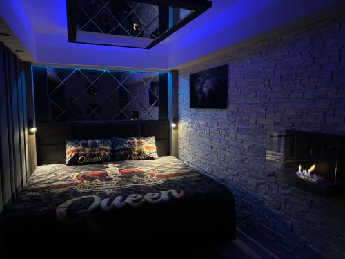 a bed in a room with a brick wall at Apartament Queen in Ełk