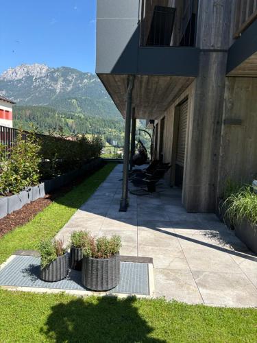 a building with two pots of plants on a sidewalk at Aloha Suite - Schladming Dachstein in Haus im Ennstal