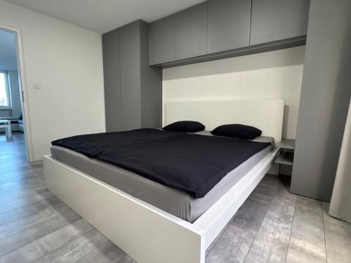 a bedroom with a large bed with black sheets at Urban apartment in Spišská Nová Ves